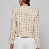 Collarless tailored jacket in a neutral tone, styled over a lightweight top