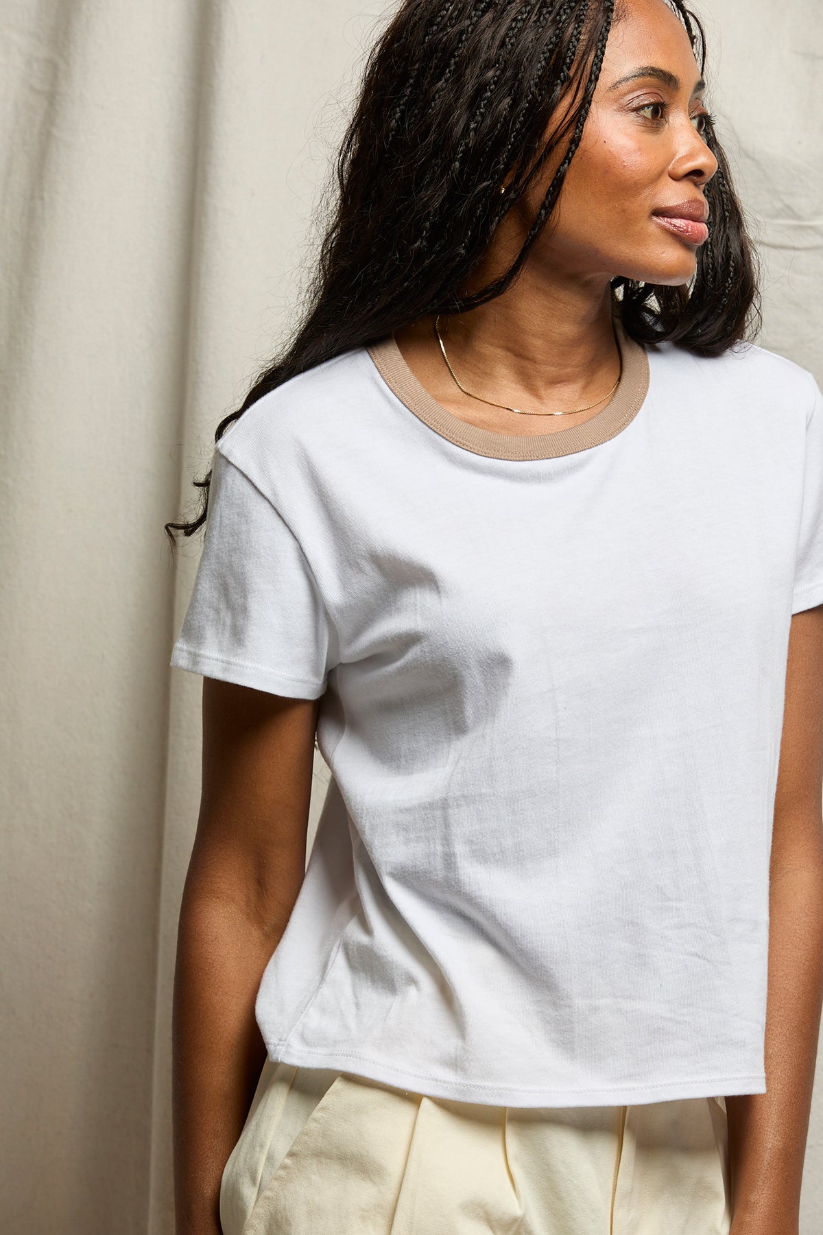 Woman wearing a plain white t-shirt against a neutral background