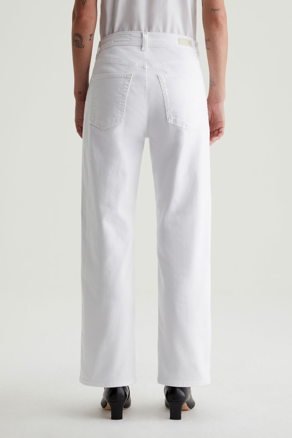 White wide-leg jeans shown from the back on a model, featuring a relaxed straight-leg fit and classic five-pocket styling.