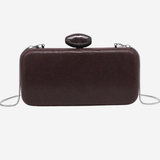 A dark brown textured leather clutch bag with a small oval black handle and a thin silver chain strap, shown against a plain white background.