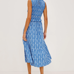 Woman wearing a blue patterned dress on a light gray background