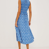 Woman wearing a blue patterned dress on a light gray background