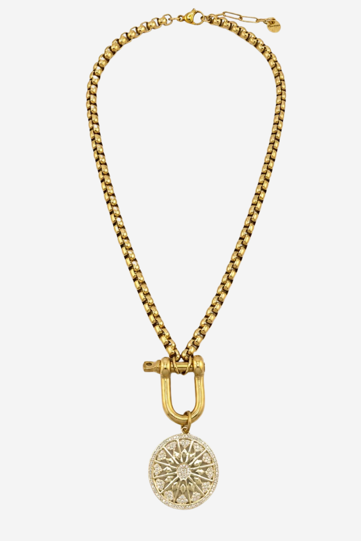 A gold-toned chain necklace featuring a large toggle clasp and a circular medallion pendant with a sunburst or floral pattern, shown against a plain light gray background.