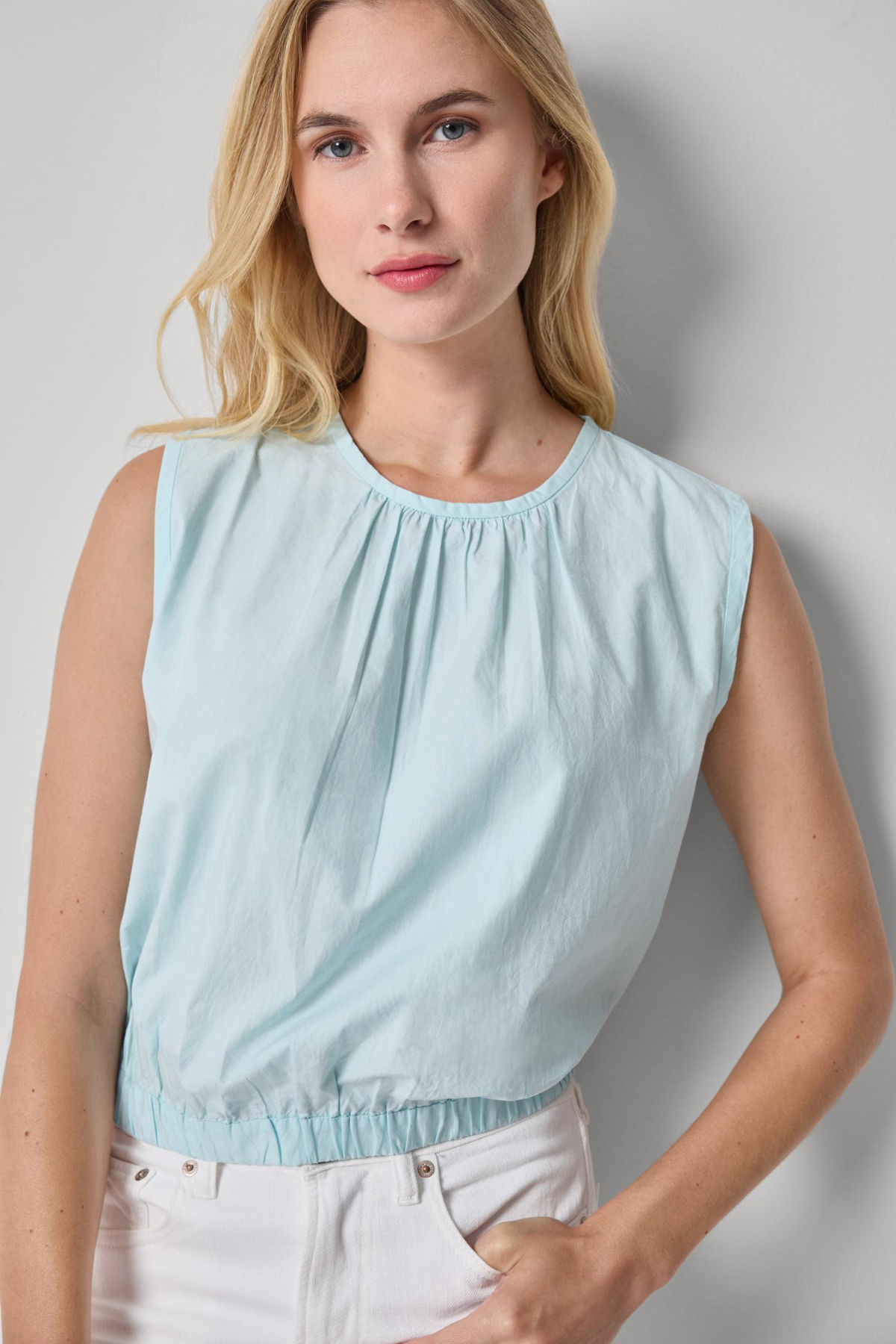 woman in blue sleeveless top on white background 