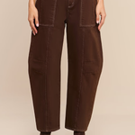 A model is shown from the waist down wearing dark brown wide-leg cropped pants with a matching dark brown belt featuring a gold buckle, paired with dark brown ankle boots against a solid beige background.