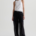 Model wearing a versatile solid-color top with a flattering silhouette styled with tailored black pants.