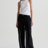 Model wearing a versatile solid-color top with a flattering silhouette styled with tailored black pants.