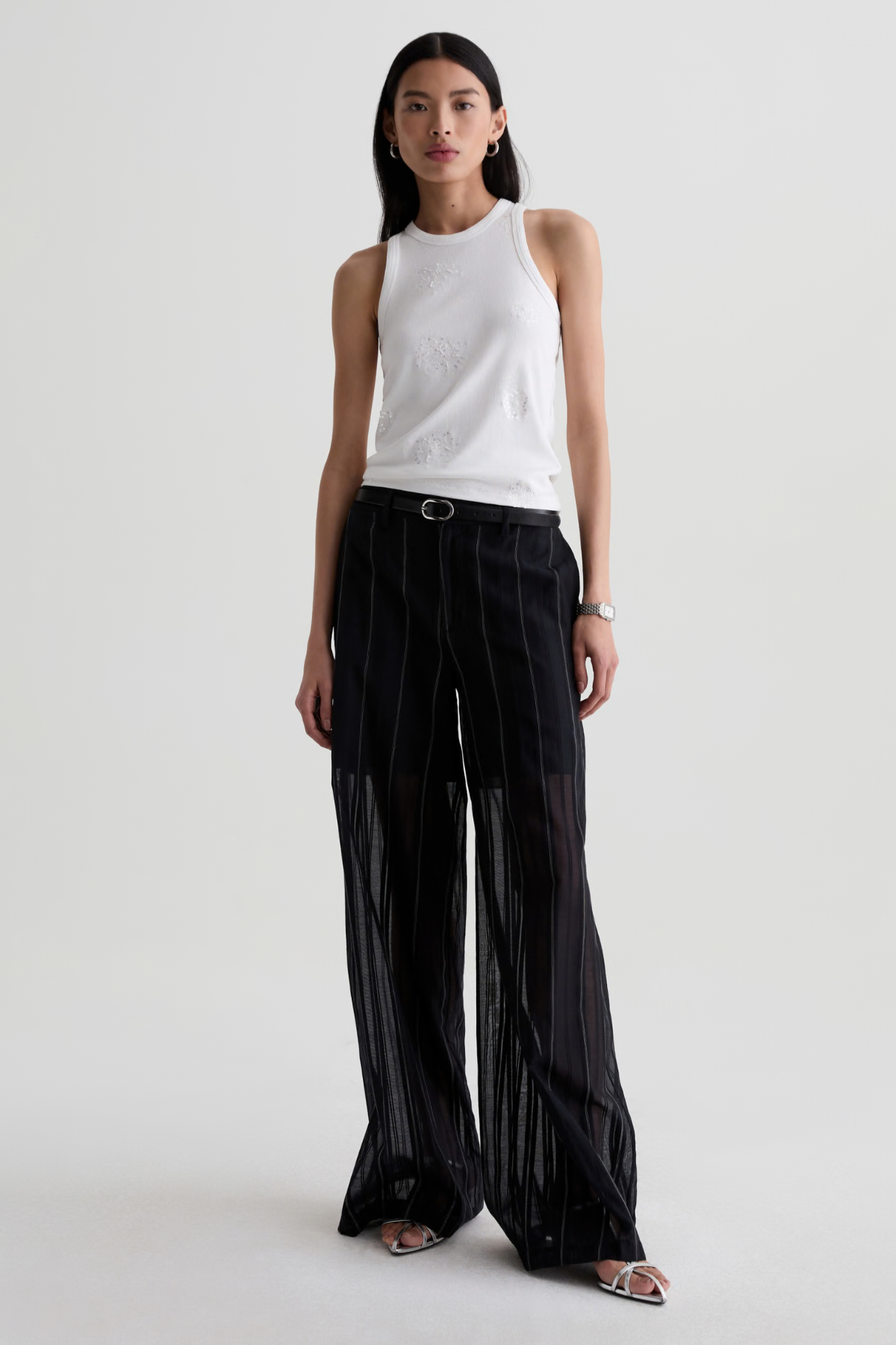 Model wearing a versatile solid-color top with a flattering silhouette styled with tailored black pants.