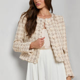 Collarless tailored jacket in a neutral tone, styled over a lightweight top