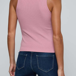 A woman shown from the back wearing a fitted sleeveless pink top and dark blue jeans against a light gray studio background.