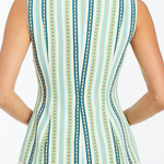 Woman wearing a sleeveless top with a green and blue striped pattern on a white background
