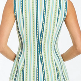 Woman wearing a sleeveless top with a green and blue striped pattern on a white background