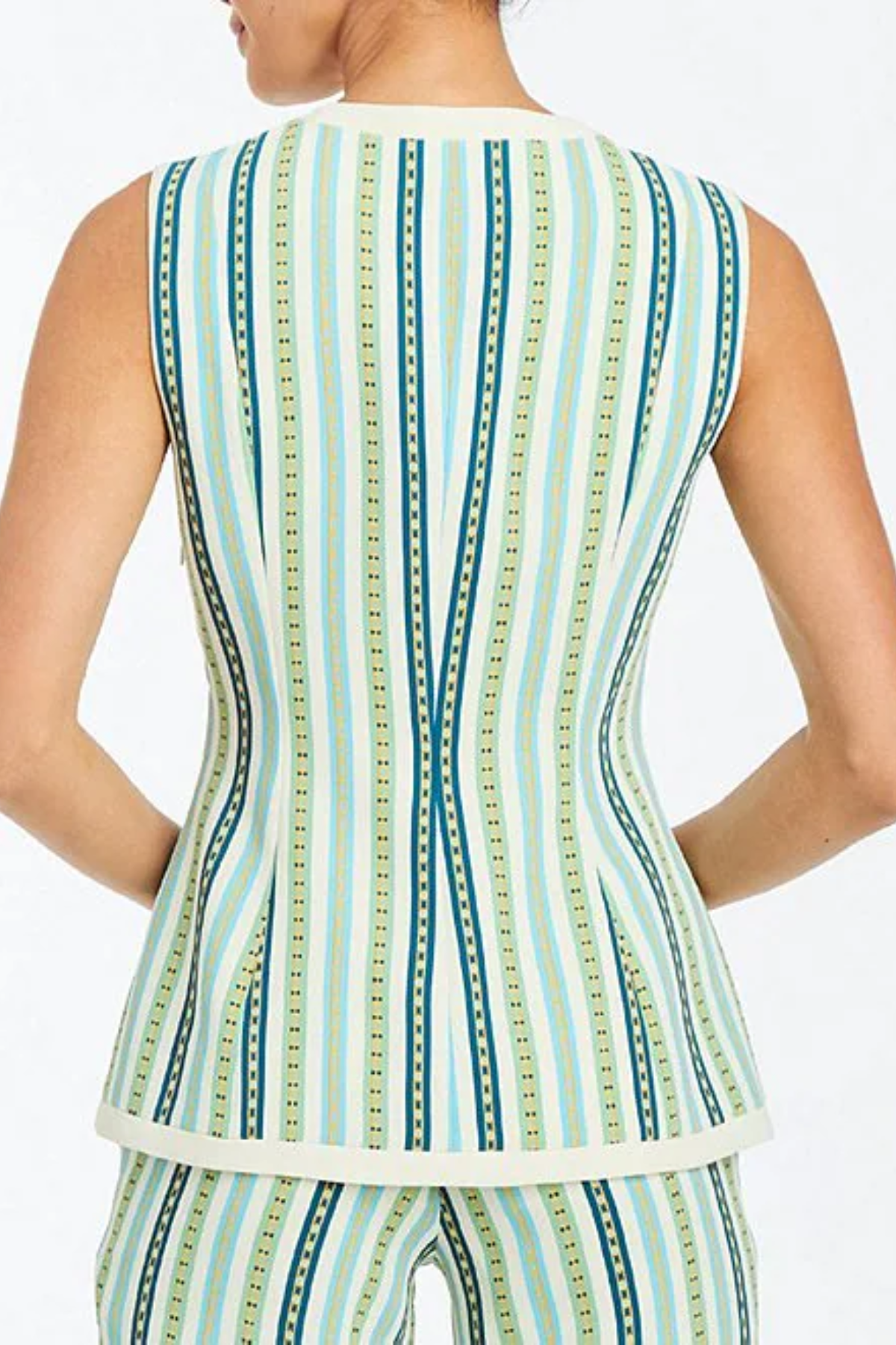 Woman wearing a sleeveless top with a green and blue striped pattern on a white background