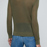 Model wearing a green knit button front sweater top with jeans on an off white background.