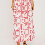 Person wearing a red and white patterned skirt on a plain background