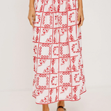 Person wearing a red and white patterned skirt on a plain background