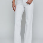 Person wearing white pants and a black and white top on a plain background