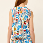 Woman wearing a colorful sleeveless dress with a pattern of fruits and other elements on a plain background