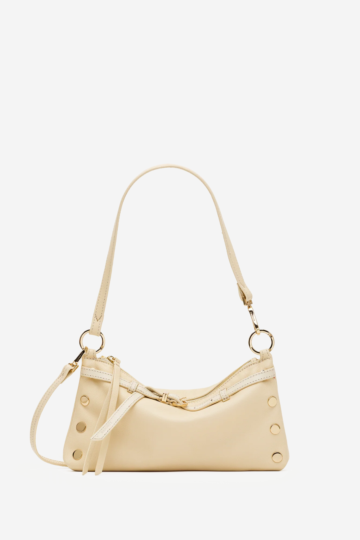 A light beige leather shoulder bag with gold-tone hardware, featuring a crescent-shaped body, a long shoulder strap, and decorative rivet details on the sides, set against a plain white background.