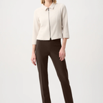 Model wearing slim-fit tailored pants with a streamlined ankle-length silhouette in a classic solid color.