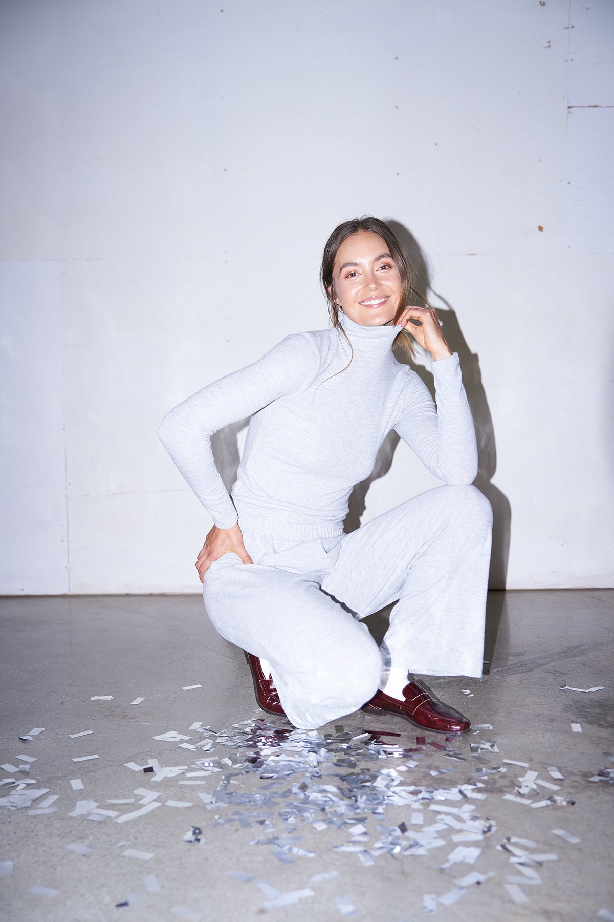 Woman wearing light grey knit pants with a straight leg silhouette, styled in soft studio lighting.