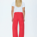 A woman viewed from the back wearing bright red wide-leg cropped pants, a white short-sleeve T-shirt, and red strappy heels against a plain white studio background.