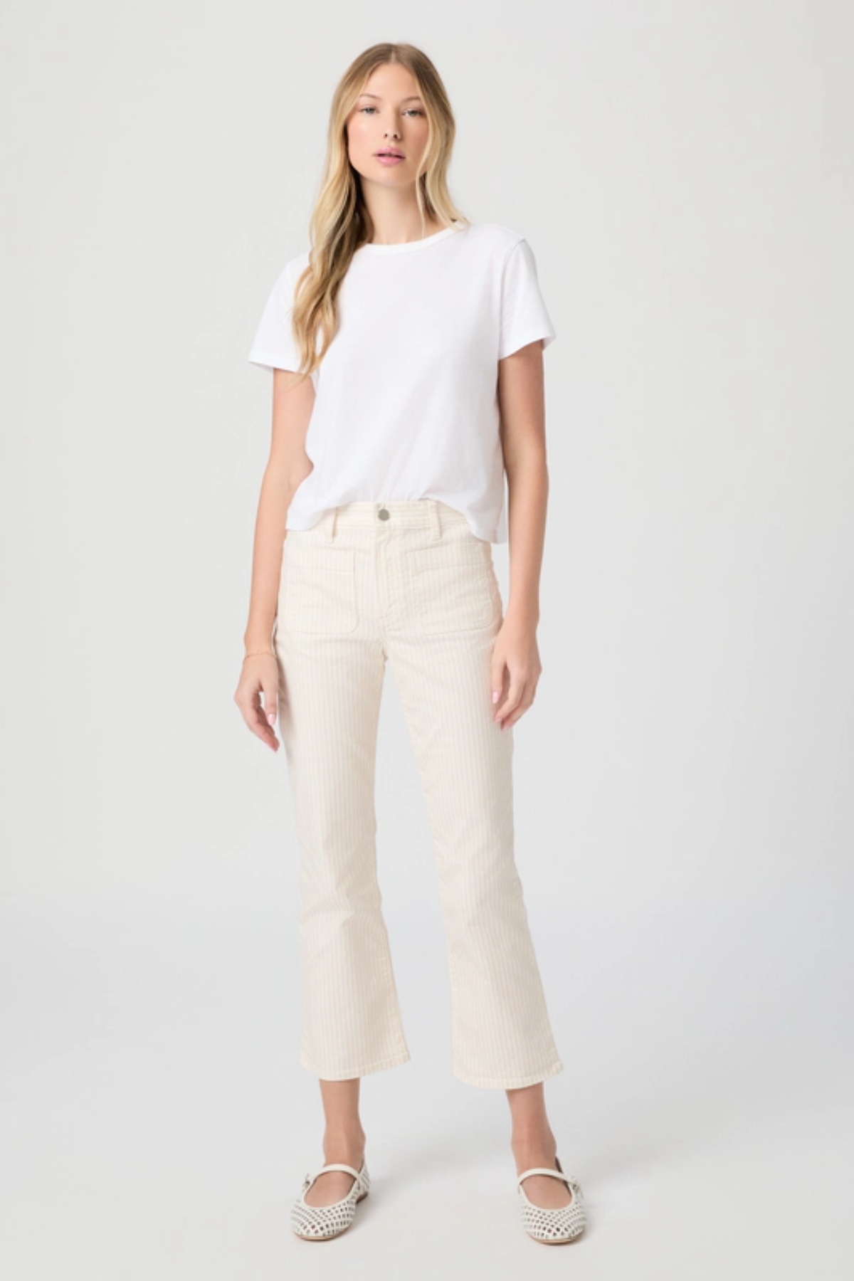 Woman wearing a white t-shirt and beige pants on a white background