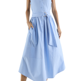 Woman wearing a light blue dress with ruffled sleeves on a white background