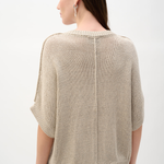 Woman wearing a beige knit sweater on a white background