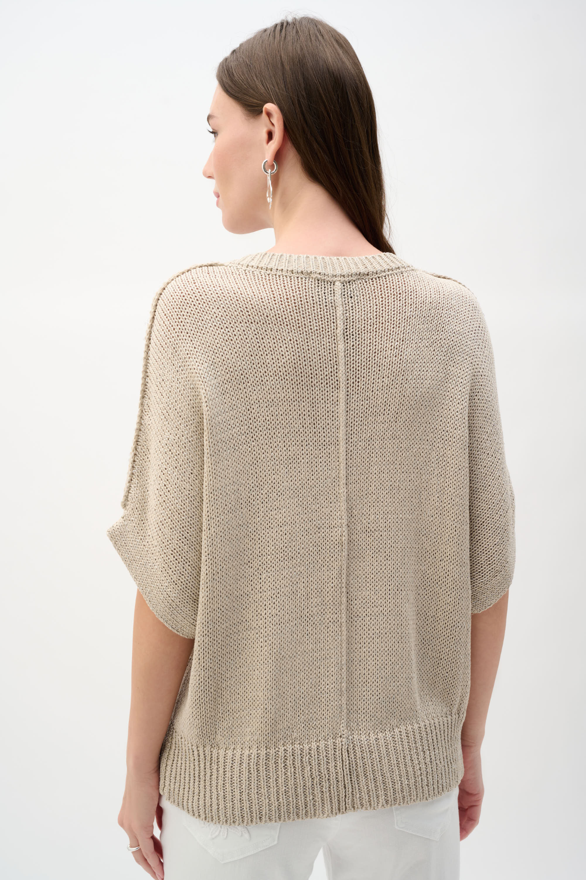 Woman wearing a beige knit sweater on a white background