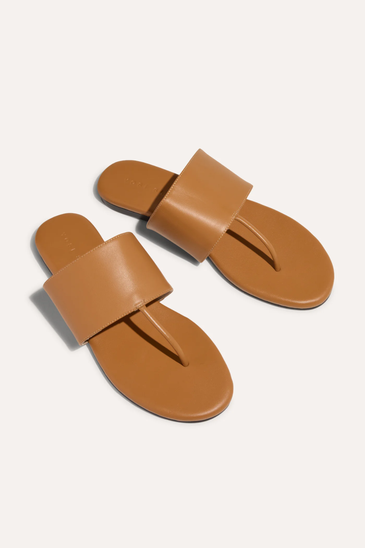 Pair of tan sandals on a white background