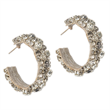 Pair of gold hoop earrings with embedded stones on a white background