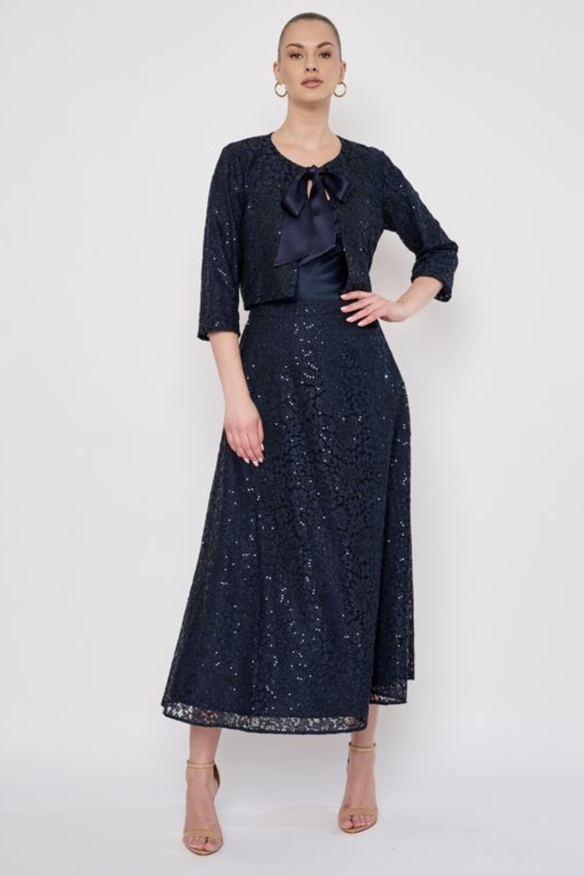 Model wearing a knee-length lace skirt with sequin detailing and a flattering fitted silhouette.