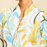Close-up of a person wearing a floral-patterned outfit with a neutral background