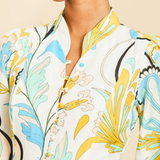 Close-up of a person wearing a floral-patterned outfit with a neutral background