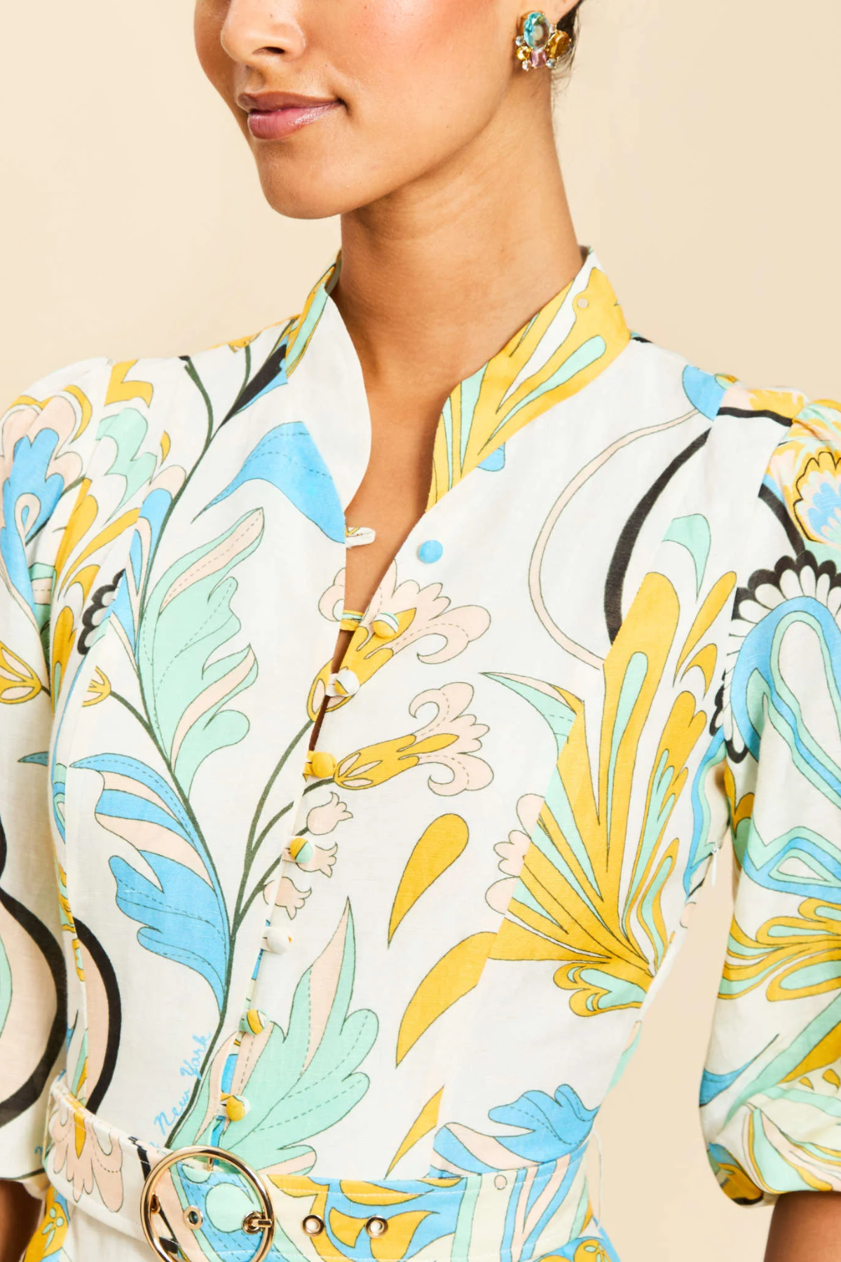Close-up of a person wearing a floral-patterned outfit with a neutral background