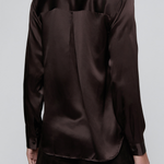 A dark brown long-sleeve satin shirt shown from the back on a model, paired with dark trousers, against a light gray studio background.