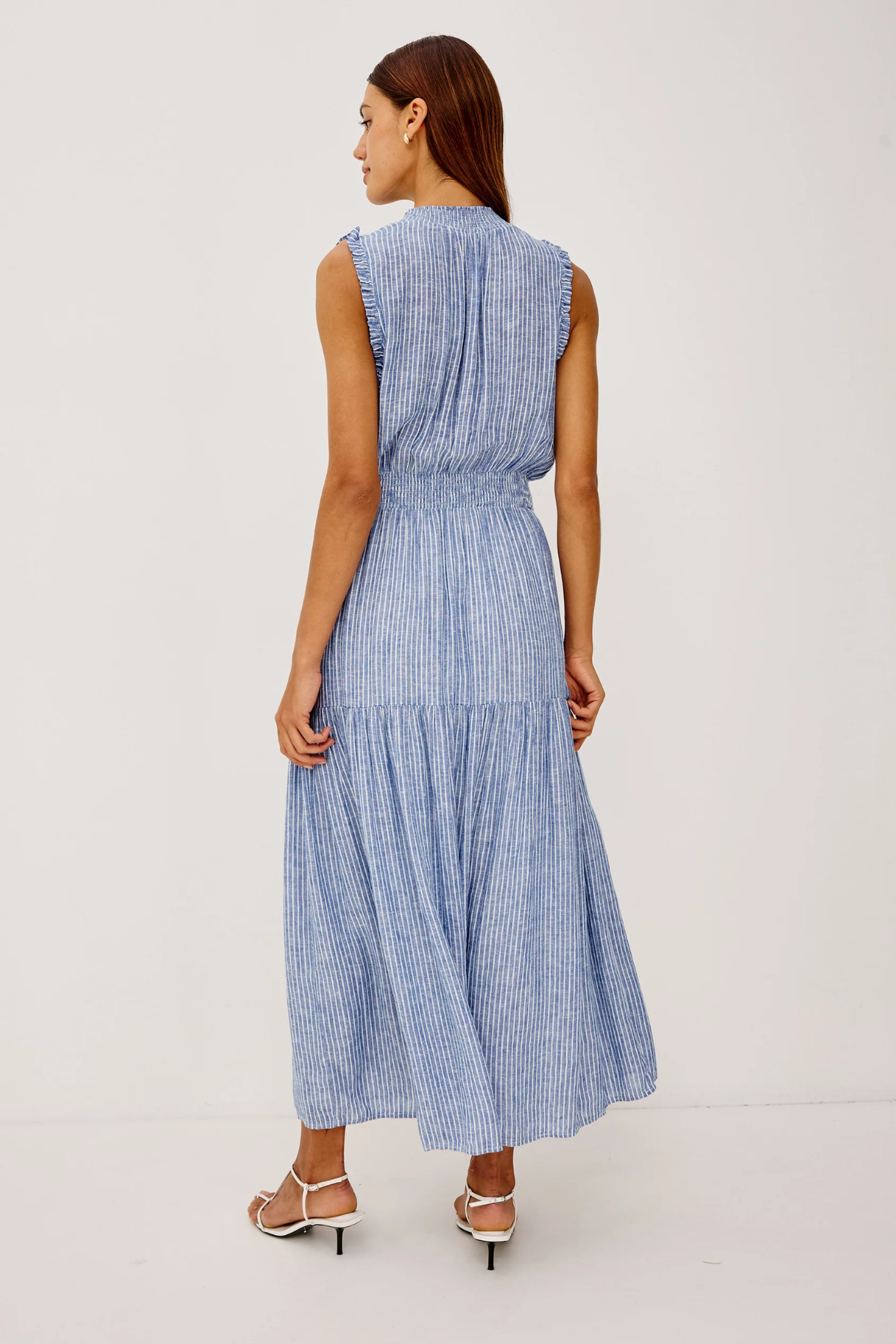 Woman wearing a blue striped dress on a white background