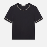 Black t-shirt with white trim on a light gray background