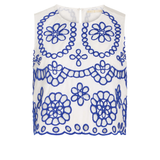 White sleeveless top with blue floral patterns on a white background