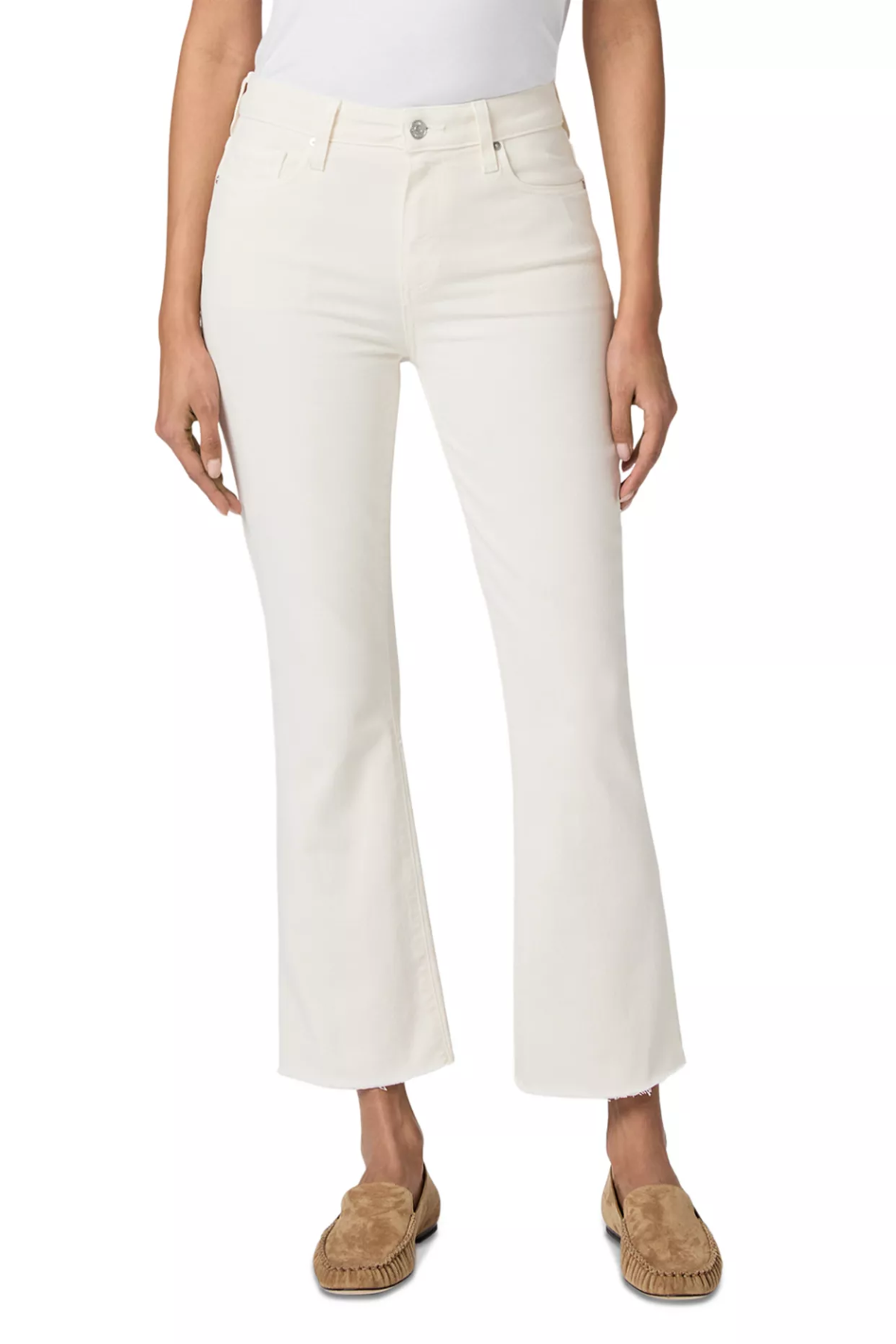 A model wearing a pair of off-white cropped flare jeans with a silver button closure, paired with a white top and tan espadrille mules, shown against a plain white background.