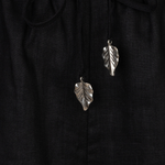 Silver leaf earrings on a black fabric background