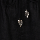 Silver leaf earrings on a black fabric background