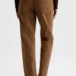 A person shown from the back wearing brown straight-leg jeans, a dark brown long-sleeve top, and black ankle boots against a light gray studio background.