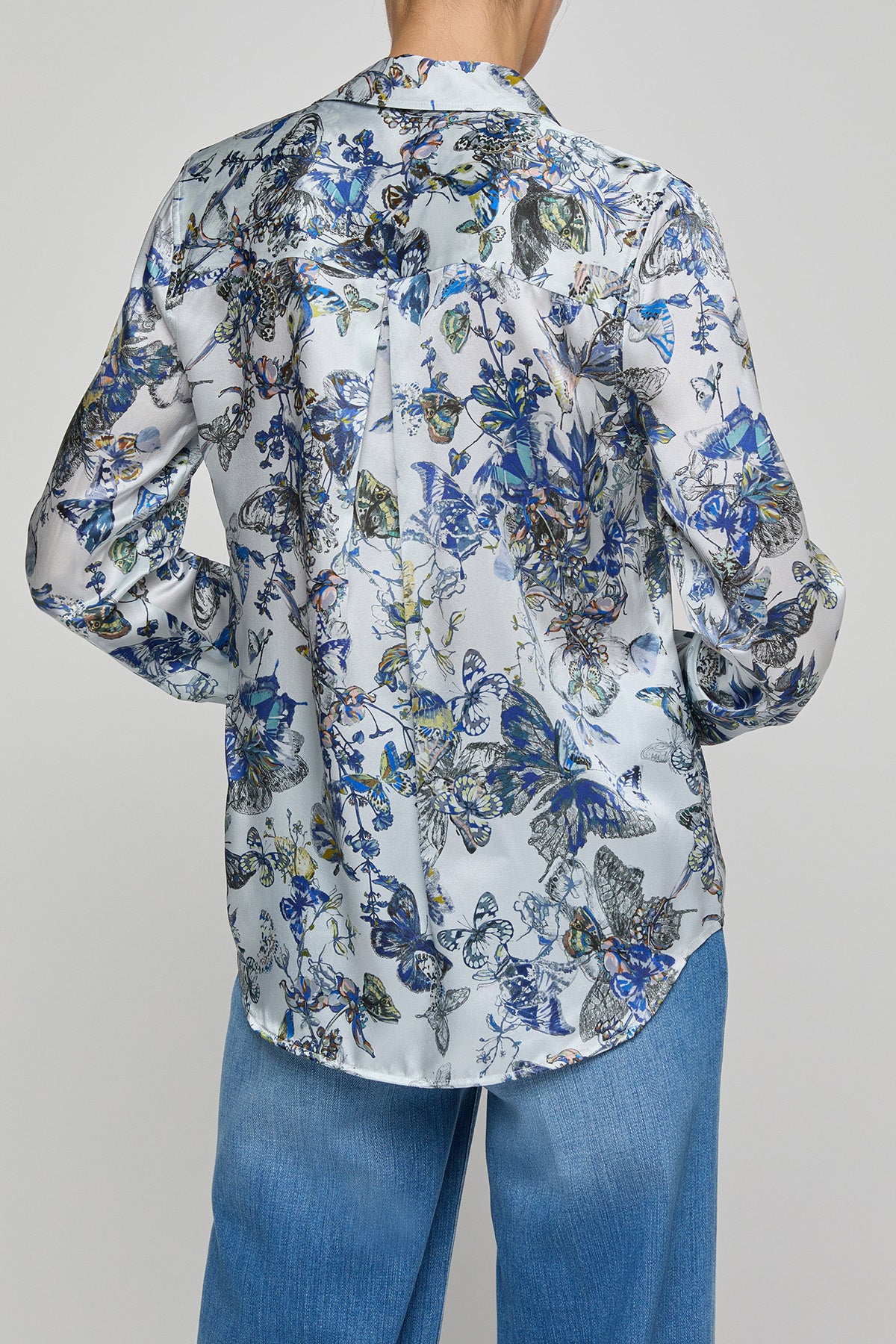 Floral patterned shirt worn by a person on a gray background