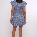 Model wearing a blue printed mini dress with short sleeves and a fitted waist.