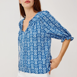 woman in blue printed blouse on white background 