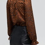 Women's leopard print burnout blouse featuring long sleeves and a semi-sheer textured finish.