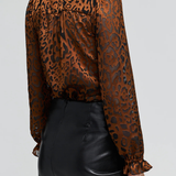 Women's leopard print burnout blouse featuring long sleeves and a semi-sheer textured finish.