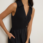 Woman wearing a black sleeveless dress against a white background